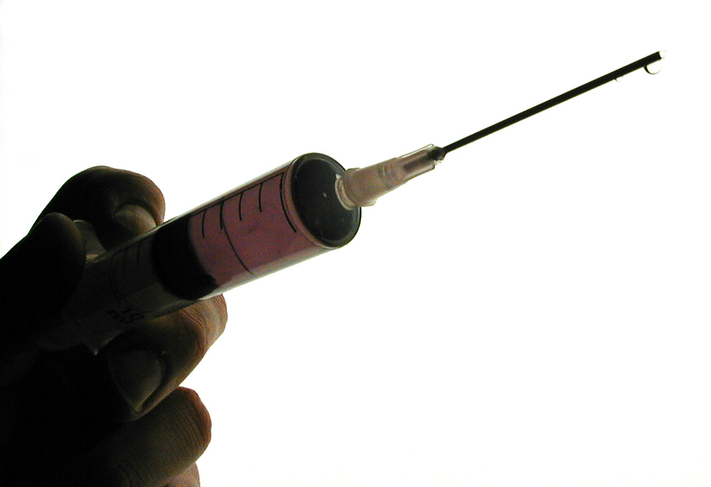 Man holding a hypodermic and needle